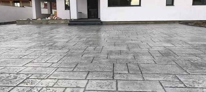 Entrada de vivienda con pavimento de hormigón impreso gris