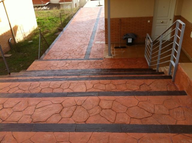Escalones de hormigón impreso terracota con bordes oscuros